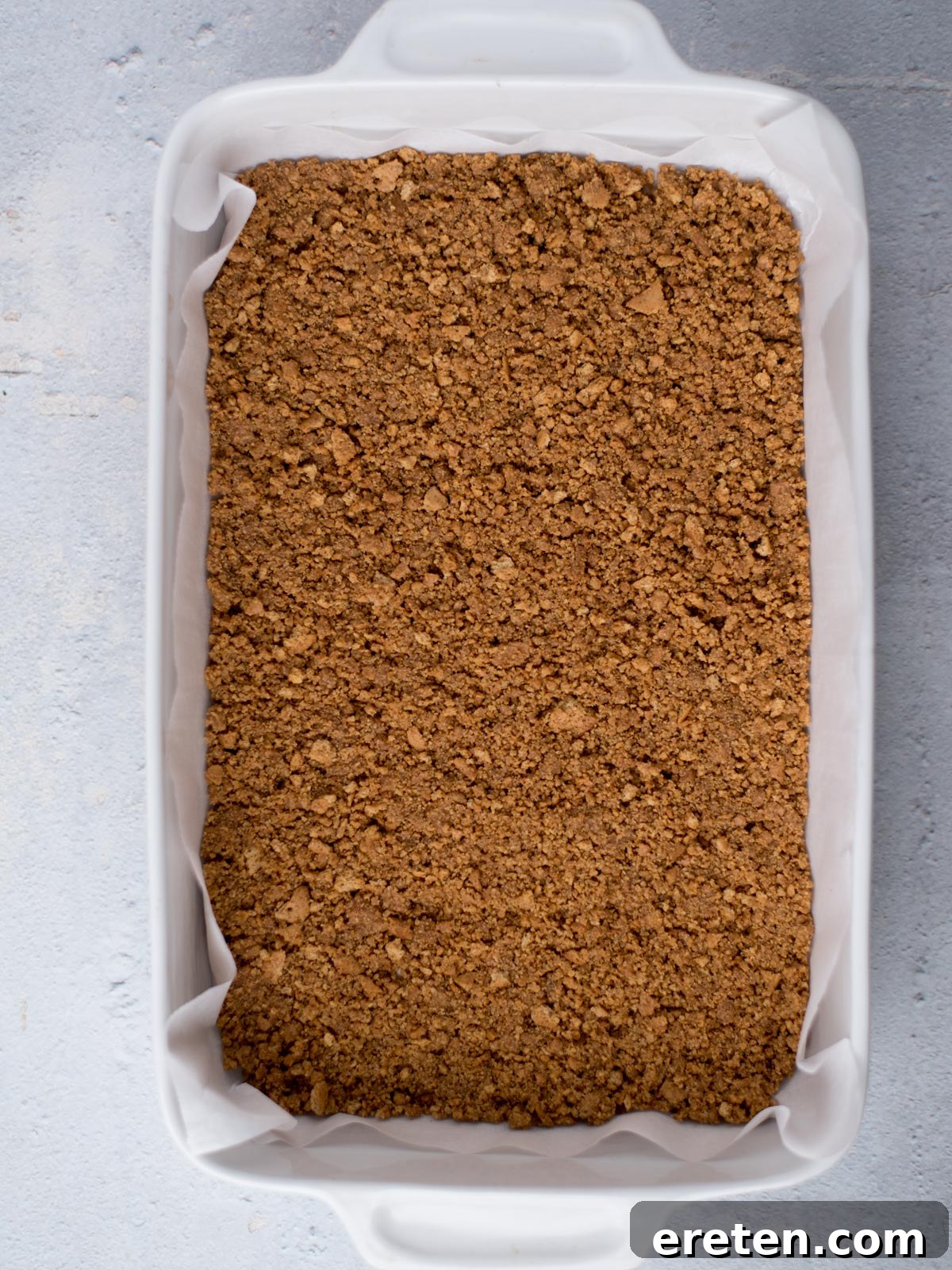 Baked graham cracker crust perfectly pressed into a 9x13 inch baking dish, golden brown and ready for the filling.