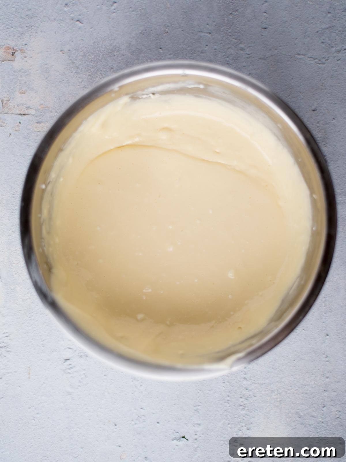 Smooth, creamy cheesecake filling after being mixed, showing a uniform texture in the bowl.