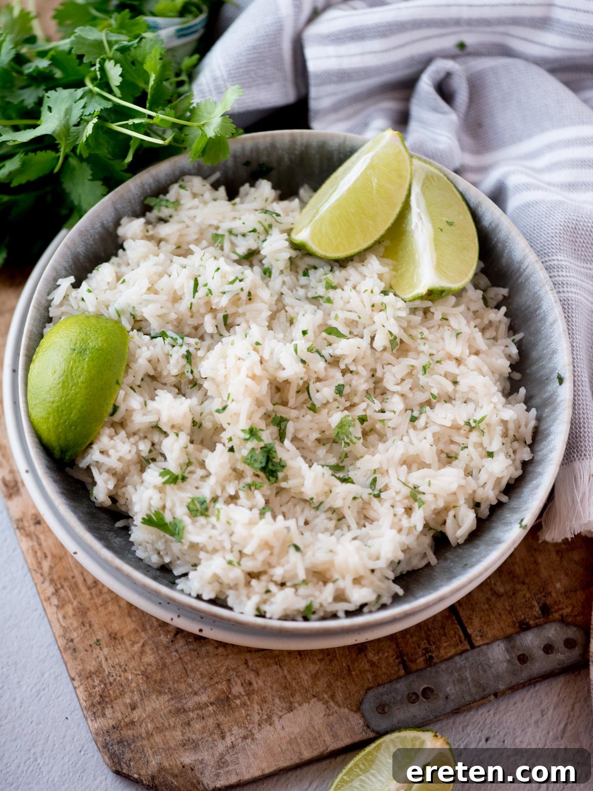 A bowl of vibrant green cilantro lime rice, garnished with freshly chopped cilantro and bright lime wedges, ready to be served.