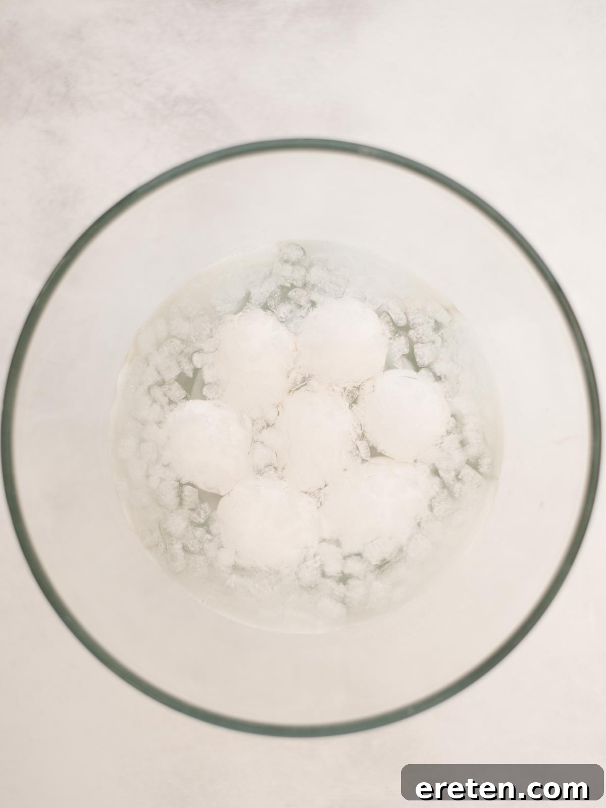 Hardboiled eggs in their shell, sitting in ice water, cooling down.