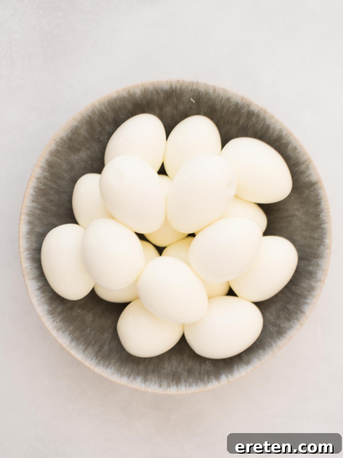 Peeled hard boiled eggs neatly arranged in a bowl.