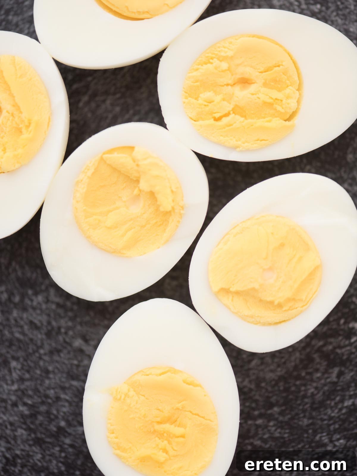 Halved hard-boiled eggs showcasing beautifully cooked, vibrant yellow yolks.