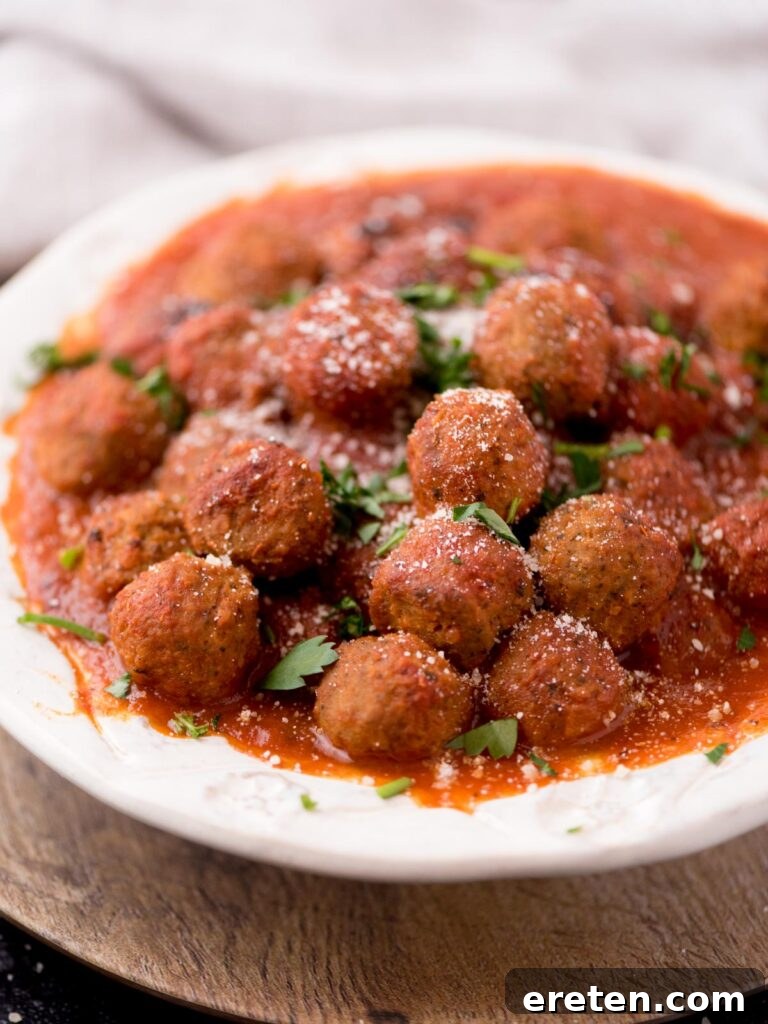 Pressure Cooker Frozen Meatballs 2 Sauce covered meatballs in a serving bowl, ready to be enjoyed.