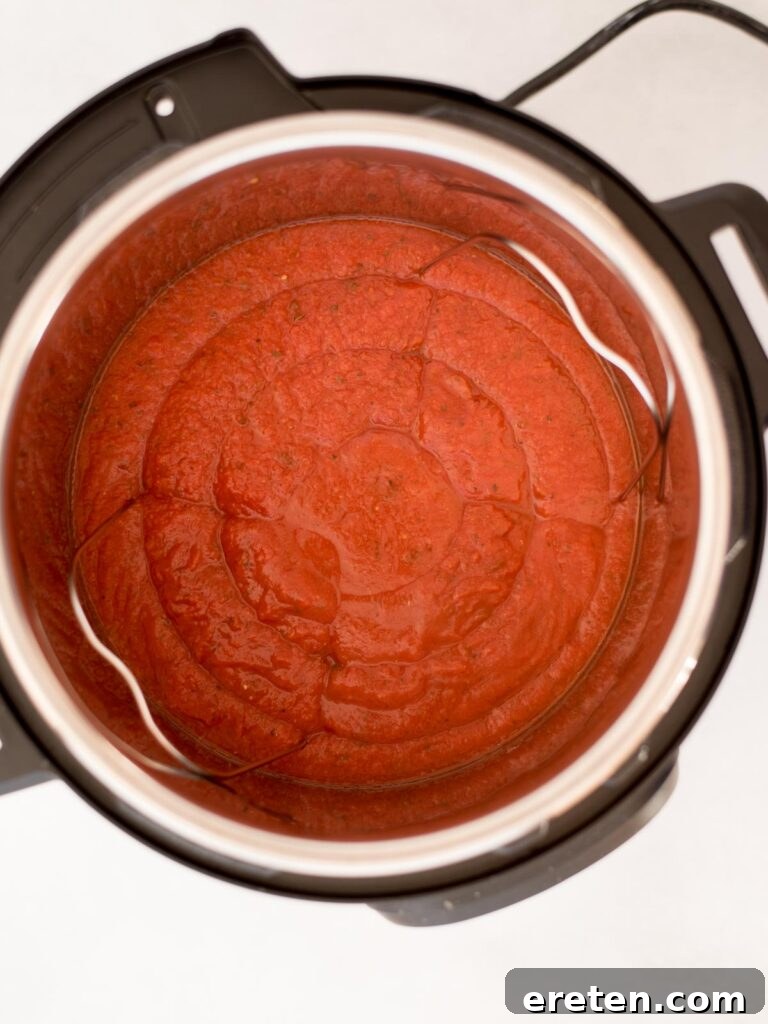Pressure Cooker Frozen Meatballs 4 Tomato sauce added to an Instant Pot liner before adding other ingredients.