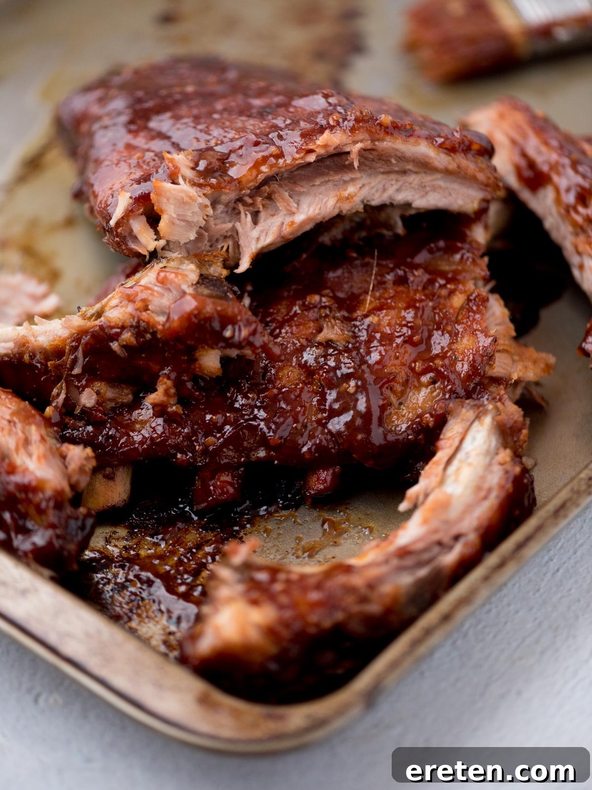 Perfectly cooked oven-baked pork ribs, glistening with barbecue sauce, ready to be served.