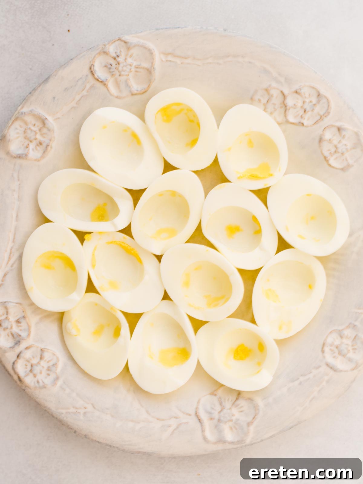 A close-up of a finished deviled egg sprinkled with paprika, ready to be served.