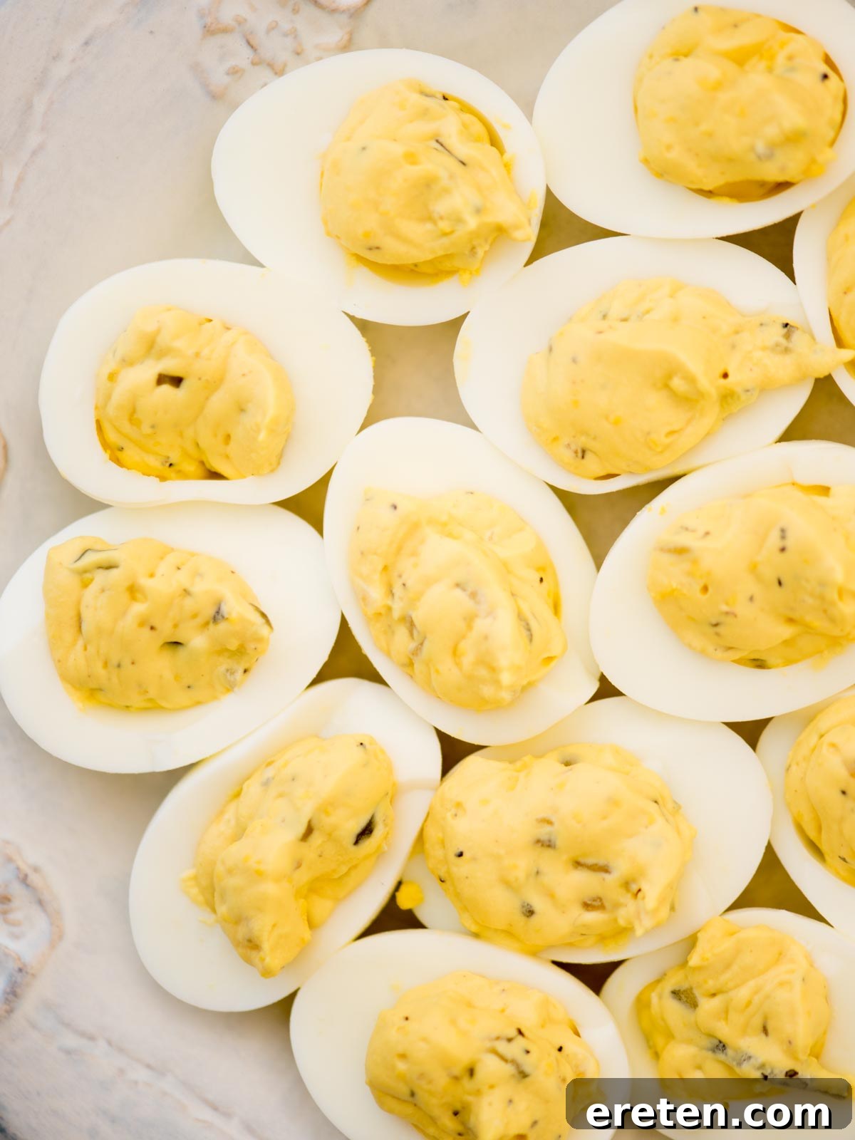 A close-up of a platter of Southern Deviled Eggs with a slight red hue from paprika.