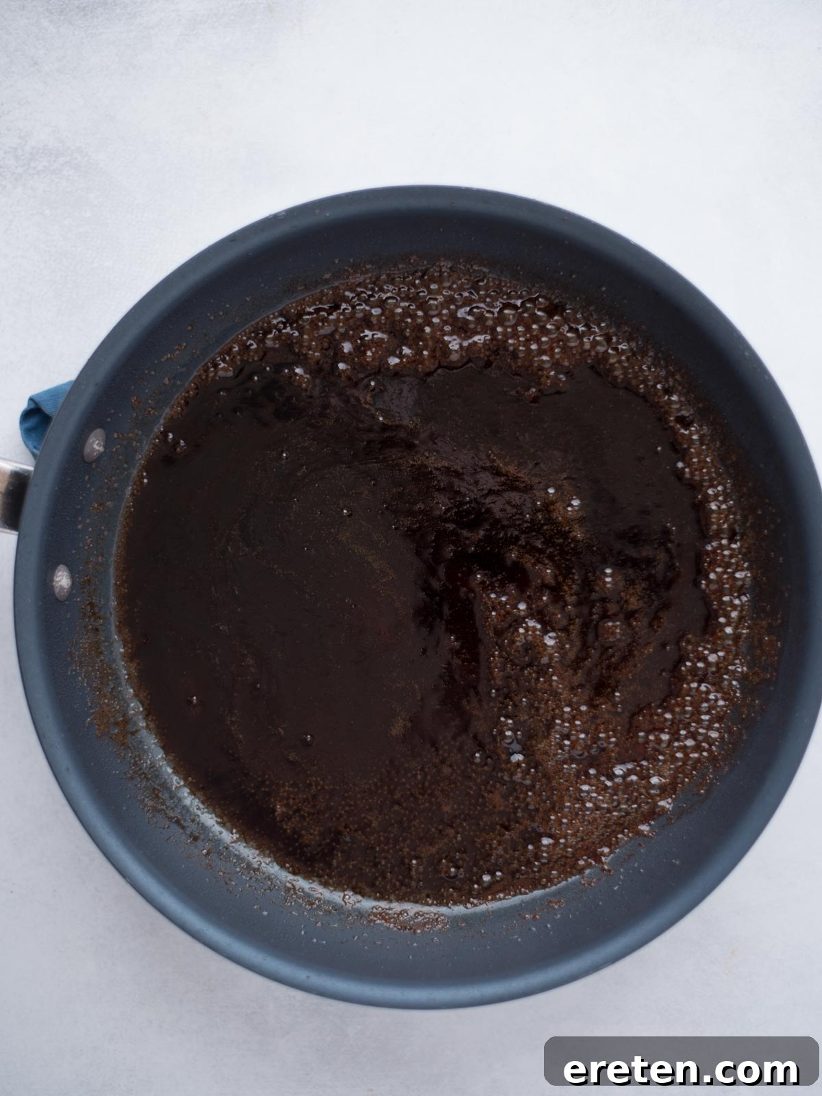 Melted butter, brown sugar, and soy sauce simmering in a skillet, creating a rich glaze.