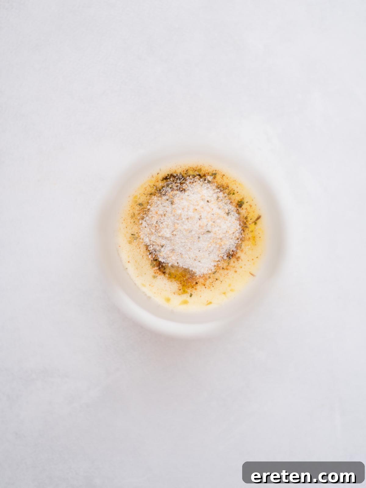 Measured seasonings added to melted butter in a small bowl for buffalo chicken sliders.