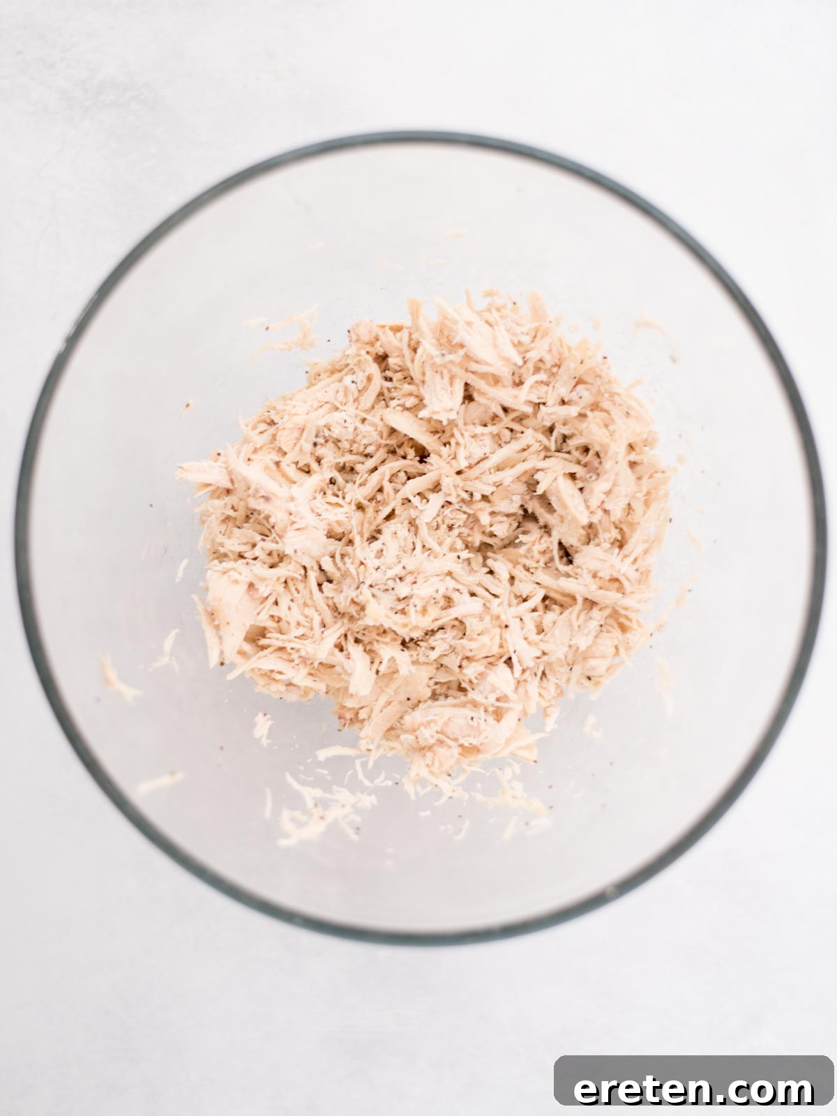 Shredded chicken in a mixing bowl.