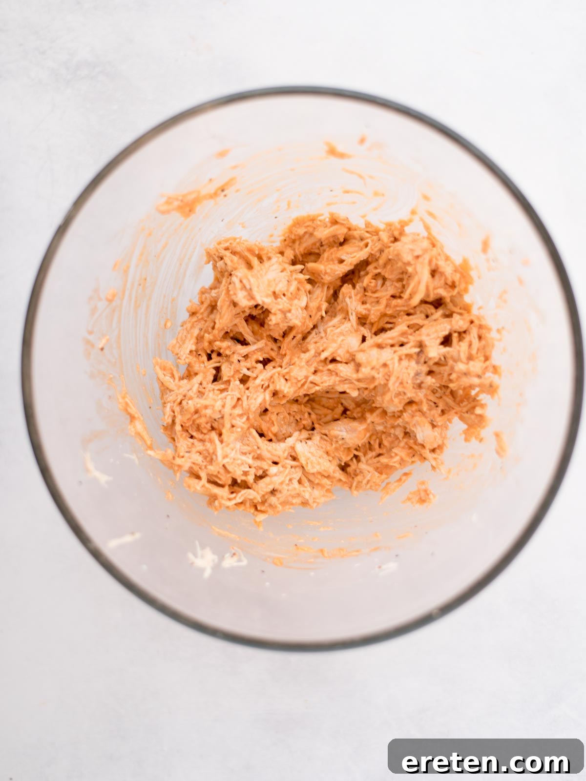 Mixing bowl with buffalo chicken mixture.