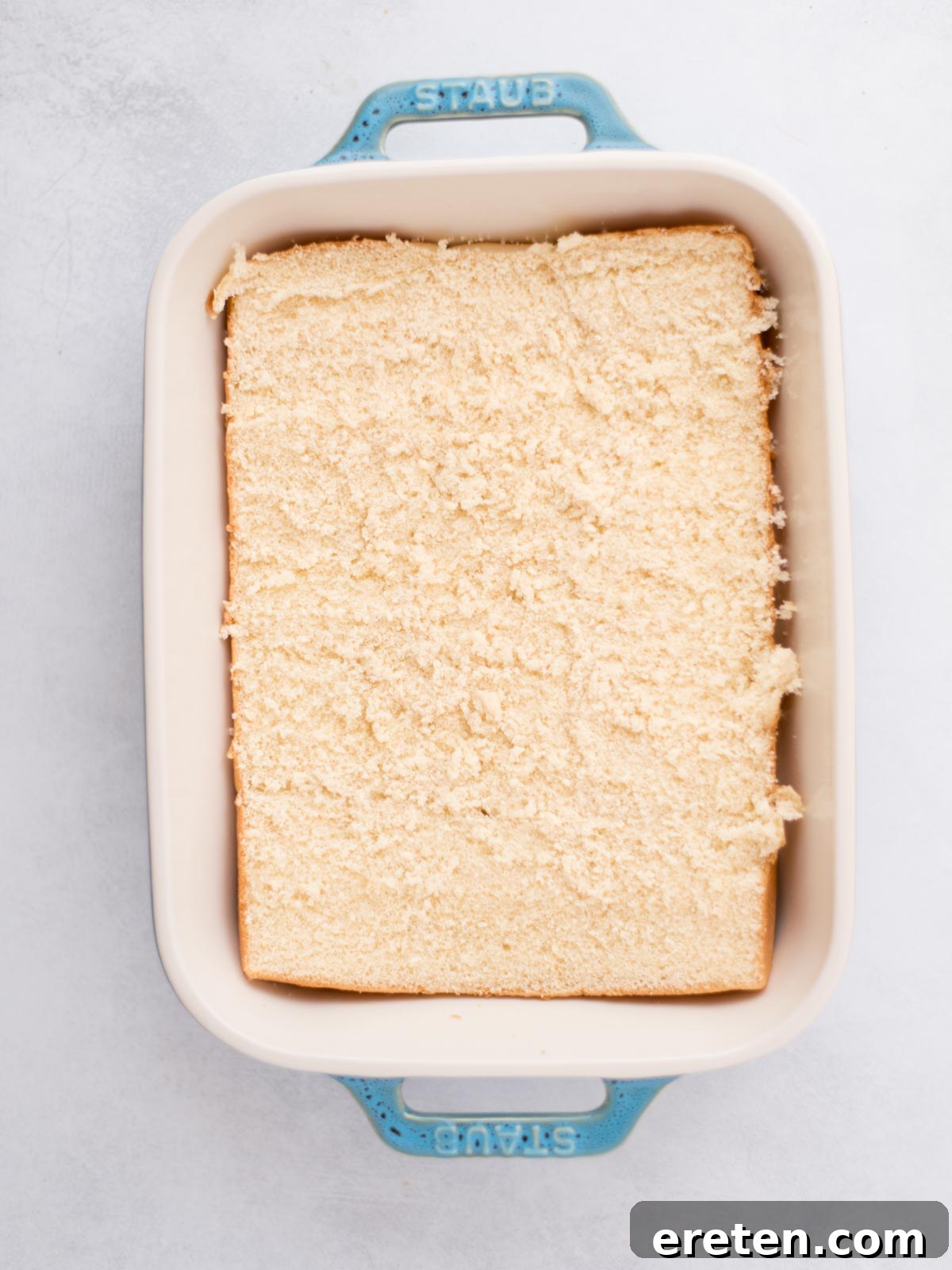 Bottom half of sliders buns placed in a baking dish.