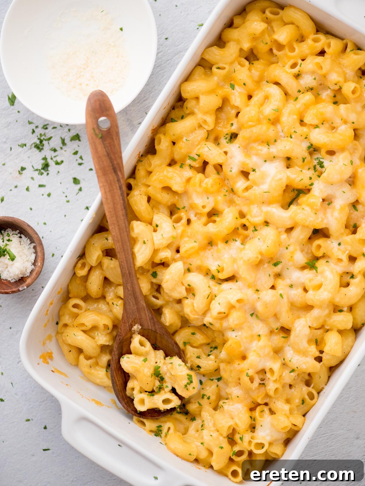 A golden-brown baking dish filled with bubbling, cheesy baked mac and cheese, topped with a crisp cheese crust and ready to be served.