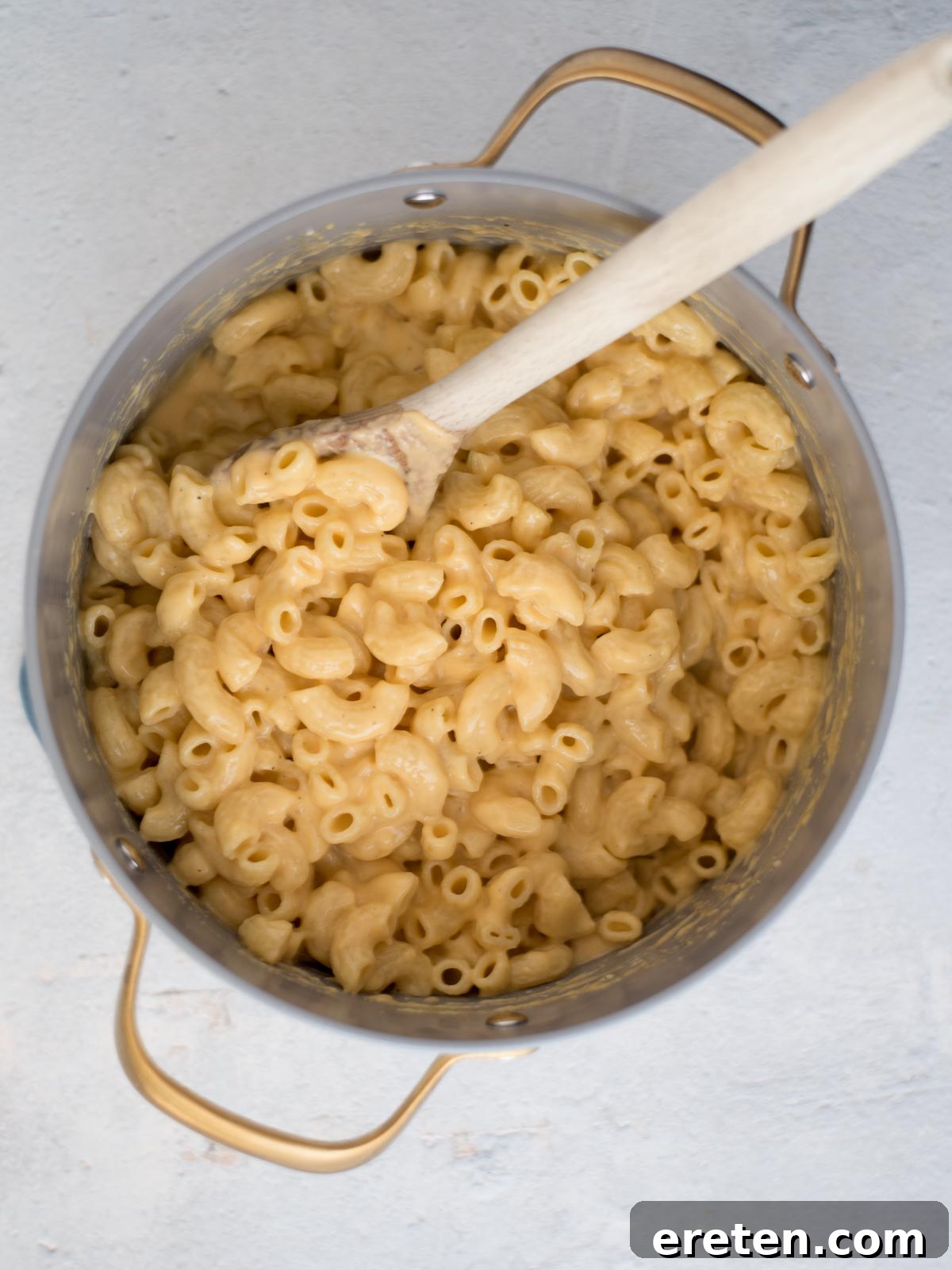 The mac and cheese mixture, now thoroughly coated with the creamy sauce, resting in a saucepan and ready to be transferred to a baking dish.