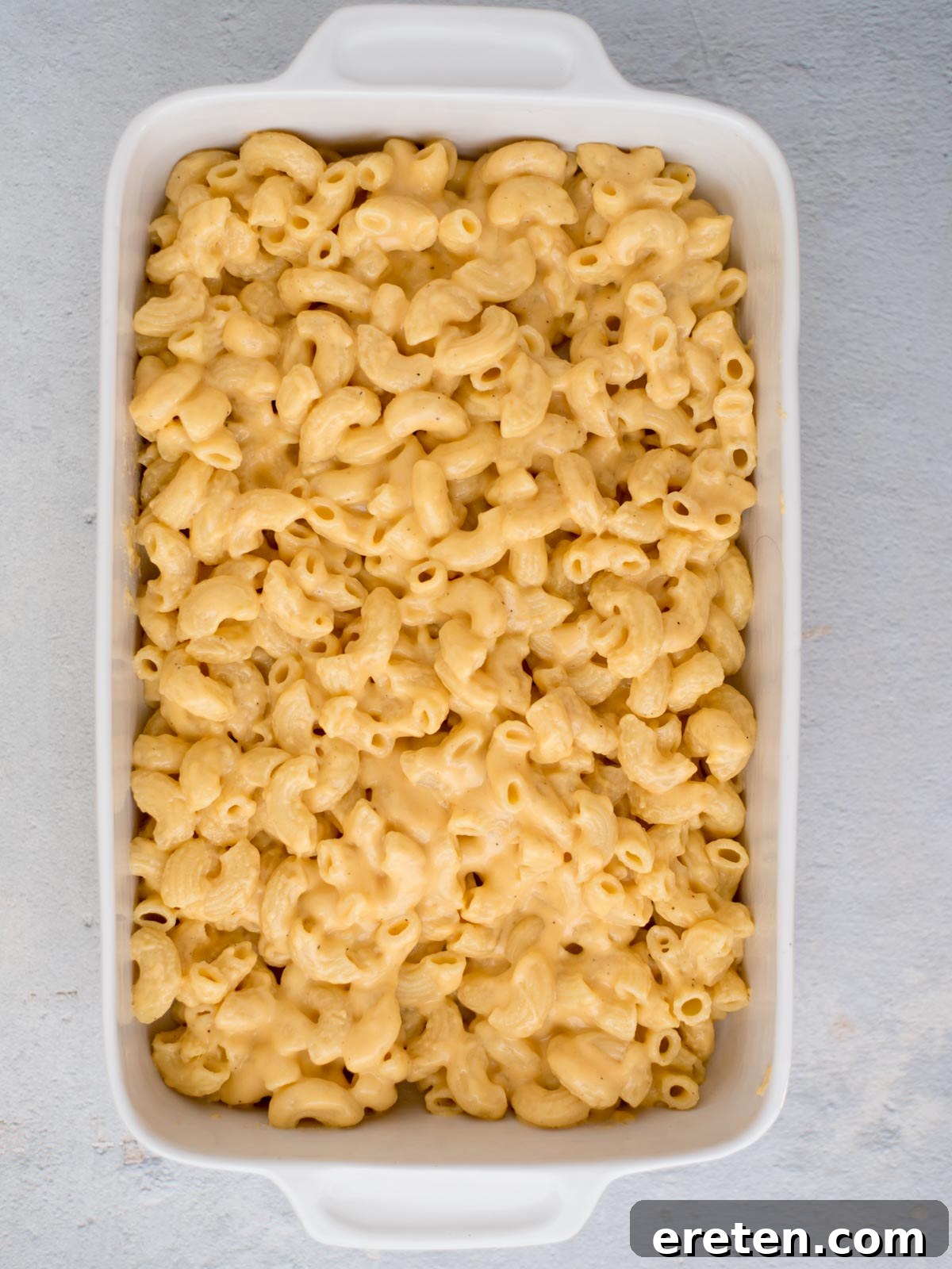 The mac and cheese mixture carefully transferred into a 9x13 inch baking dish and spread evenly, ready for its final topping.