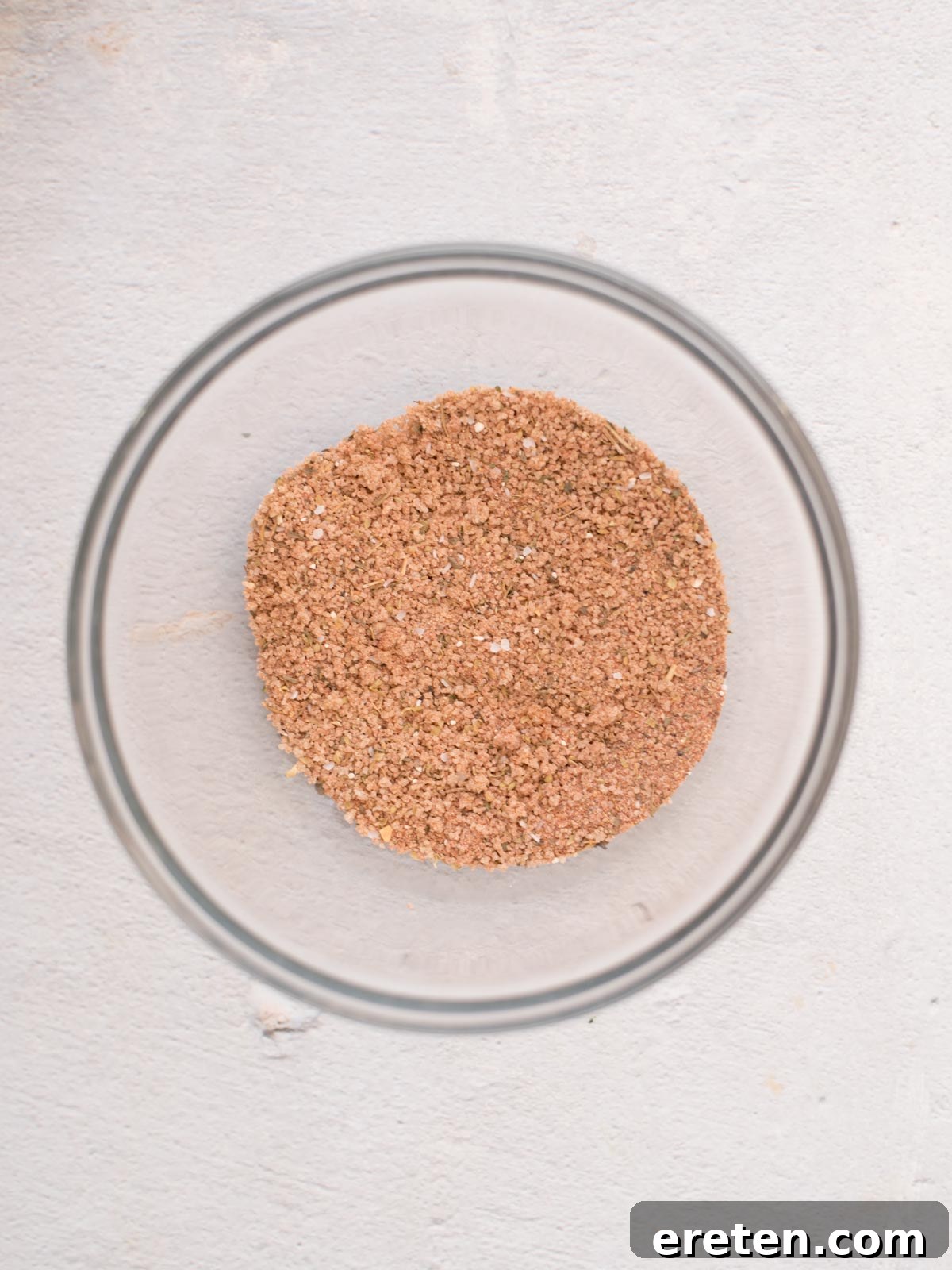 The combined seasonings for the pork tenderloin are thoroughly mixed together in a small glass mixing bowl, forming an even rub.