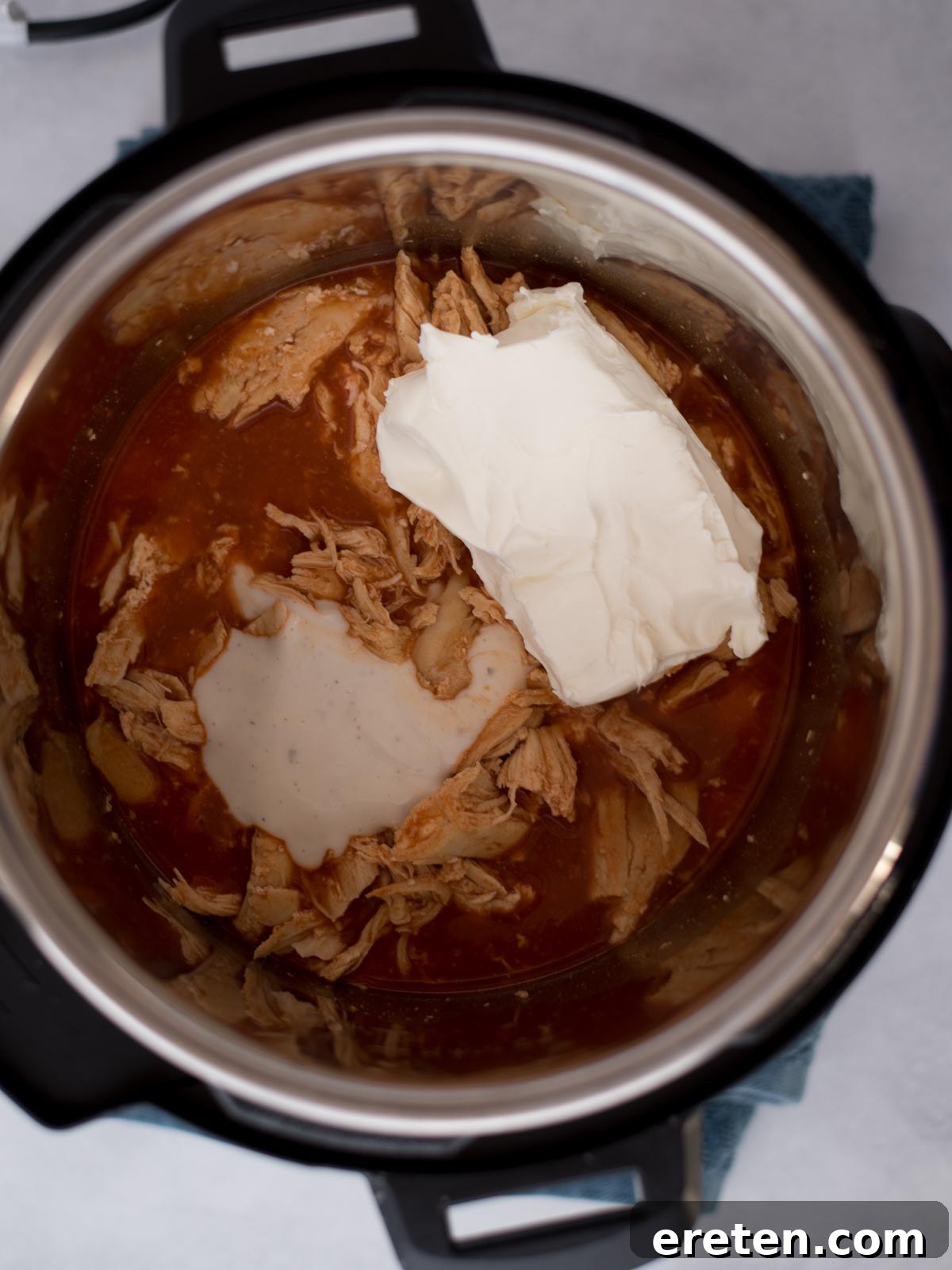Instant pot filled with ingredients for buffalo chicken dip, ready to cook.