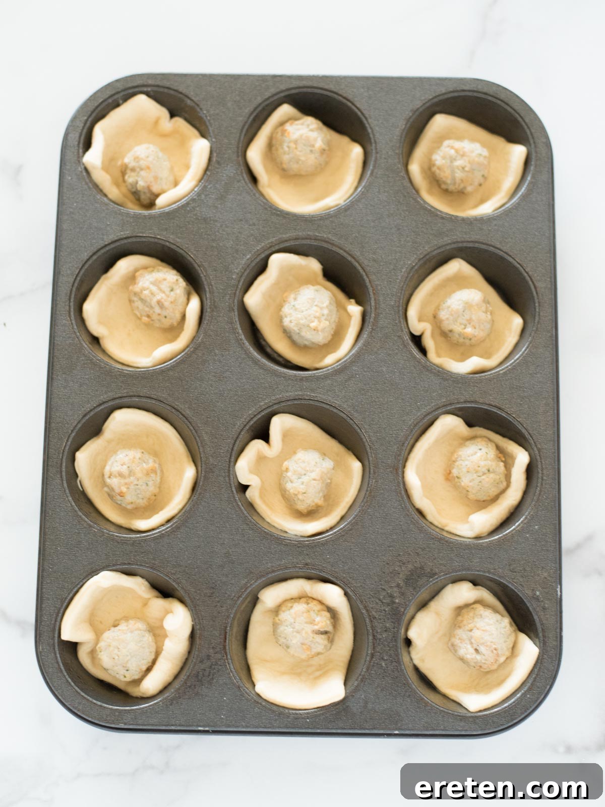 Touchdown BBQ Meatball Crescents 5 Meatballs nestled on crescent dough squares in a muffin tin, pre-sauce.