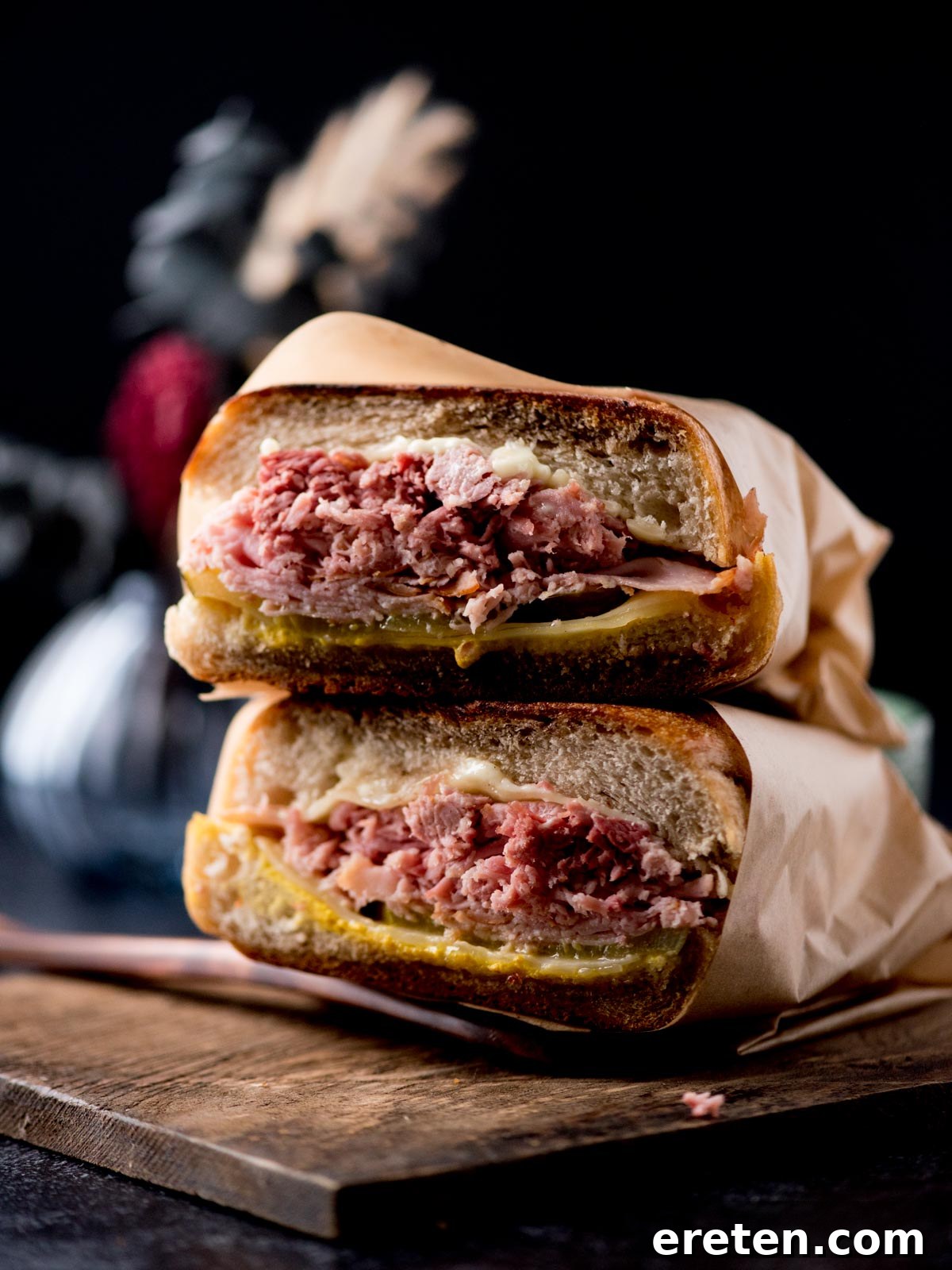 Effortless Classic Cuban Sandwich 2 stacked cuban sandwiches on a bread board with a golden brown crust