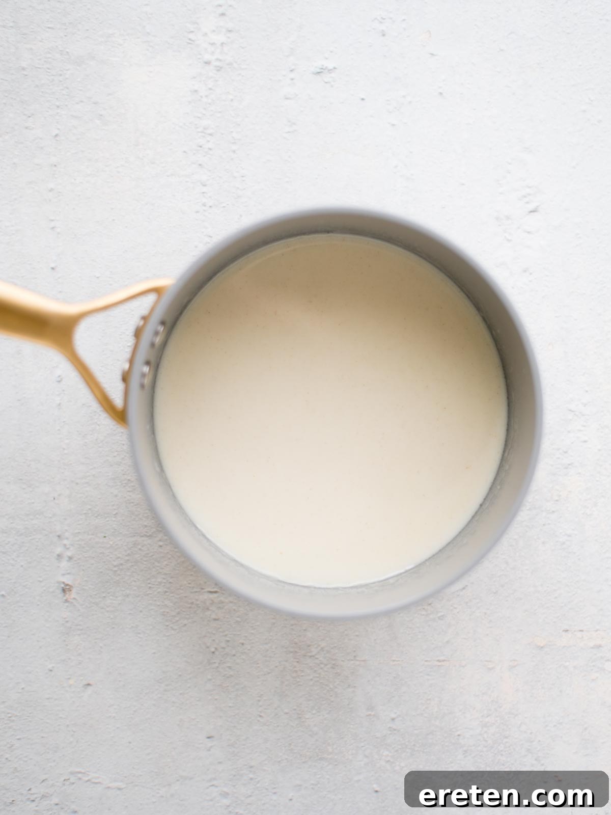 Step-by-step image showing the formation of a smooth roux in a saucepan, followed by the addition of milk and beer, creating a creamy base for the dip.