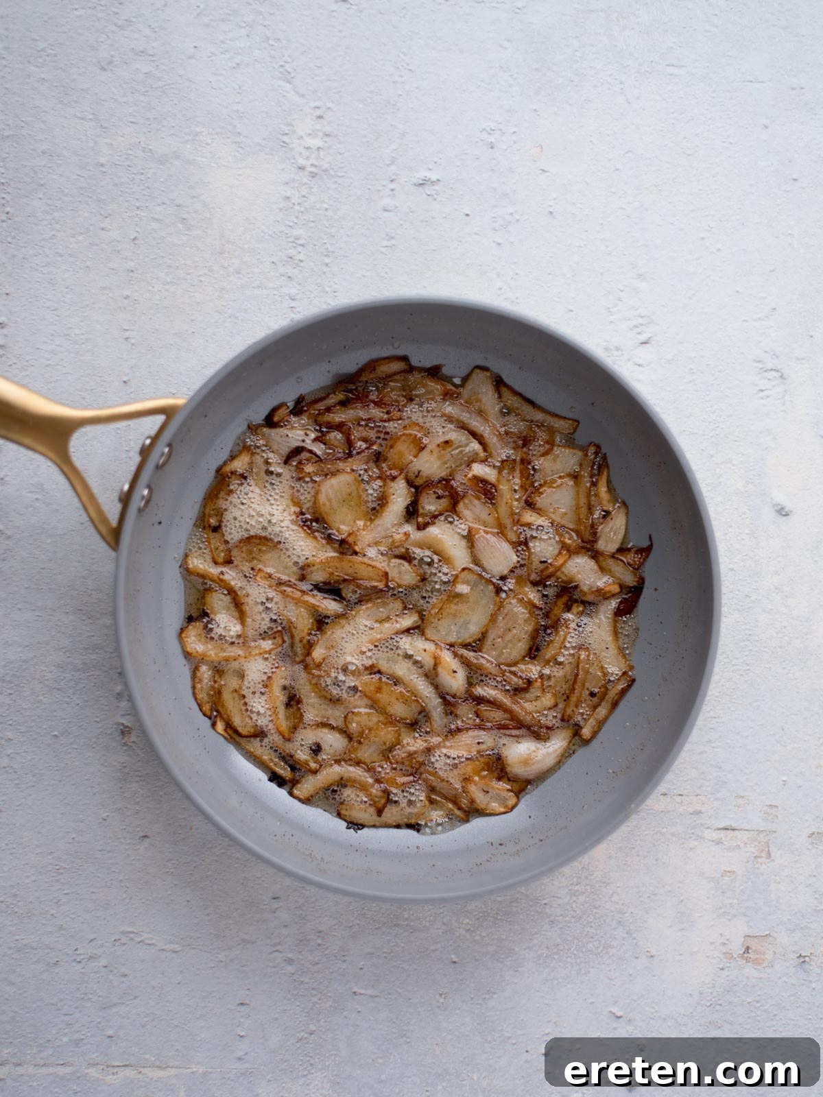 Gravy Smothered Hamburger Steak 5 Translucent, softened sliced onions gently sautéing in a skillet, forming the flavorful base for the gravy.