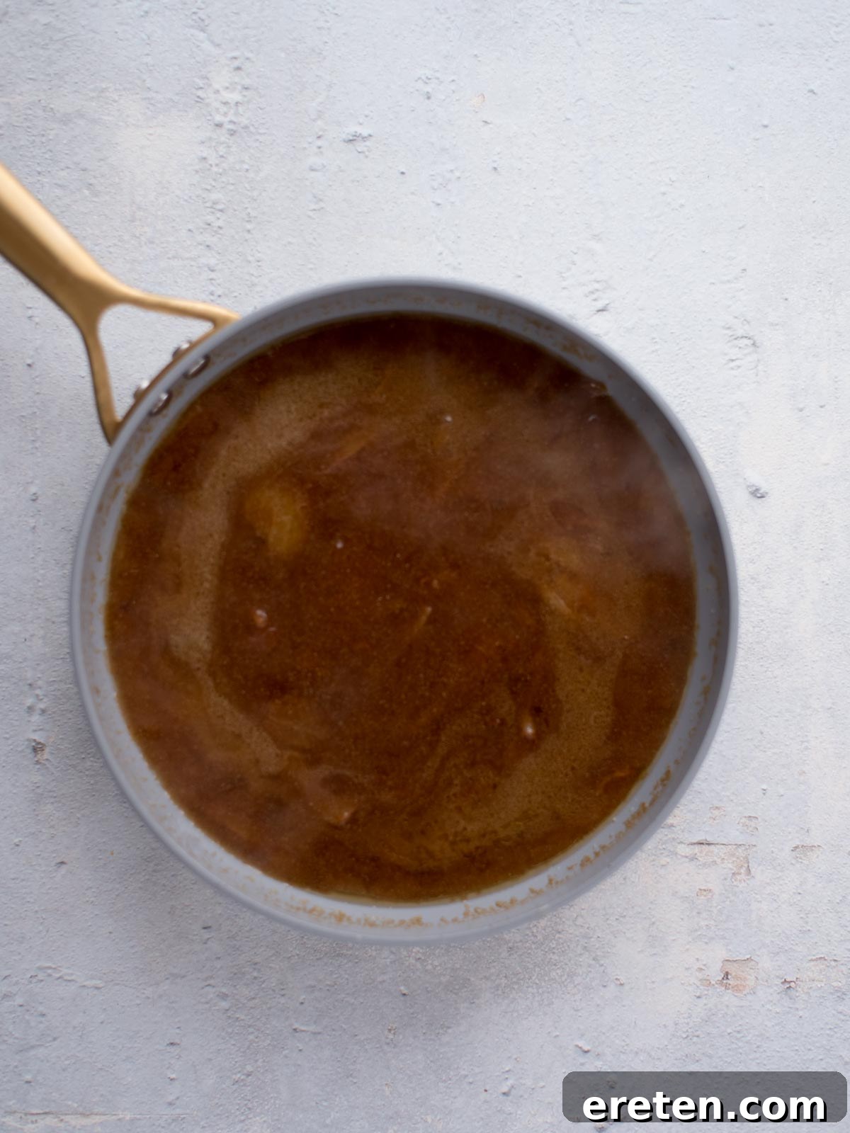 Gravy Smothered Hamburger Steak 6 Rich, thick brown gravy simmering in a skillet, ready to embrace the hamburger steaks.