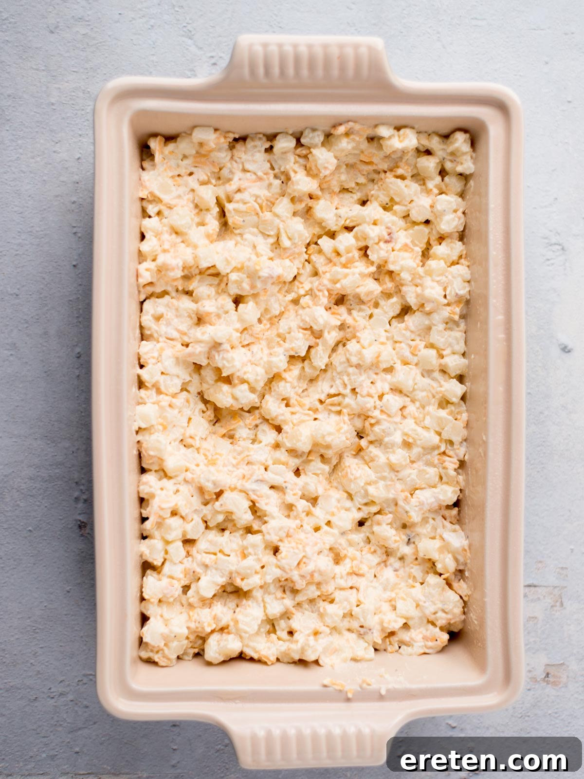 The cheesy potato mixture carefully spread into a 9x13 inch baking dish, ready for the topping.