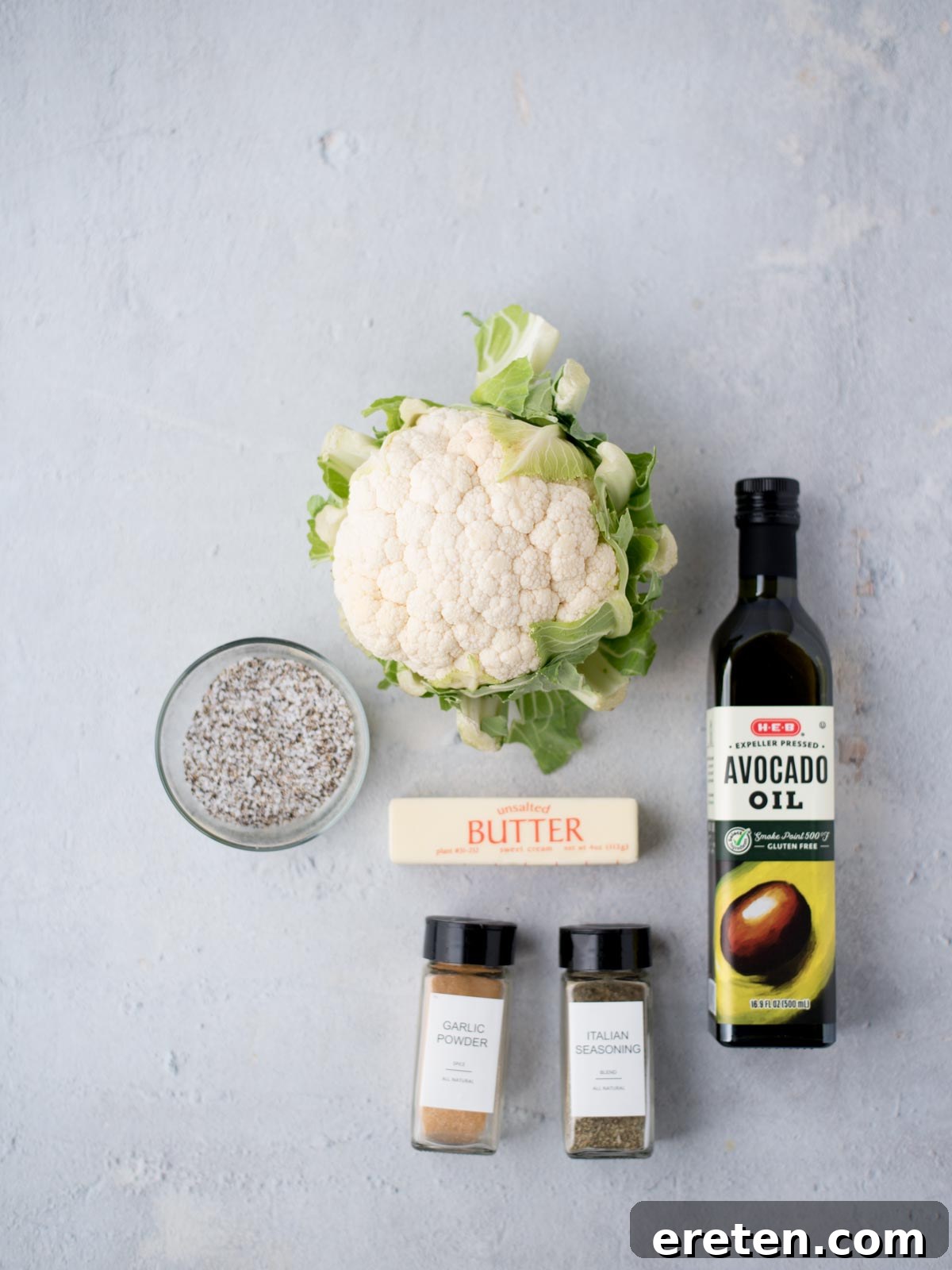 ingredients to make roasted cauliflower including cauliflower, oil, butter, and seasonings
