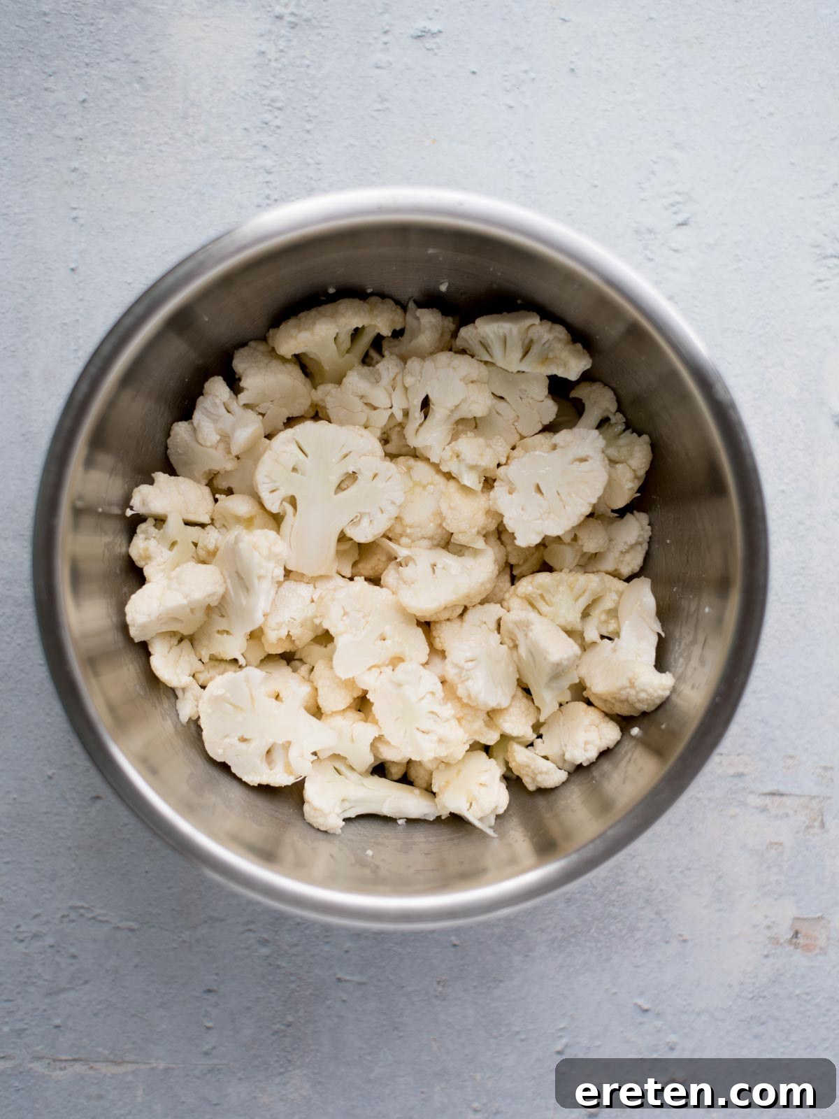chopped cauliflower in a mixing bowl before seasoning