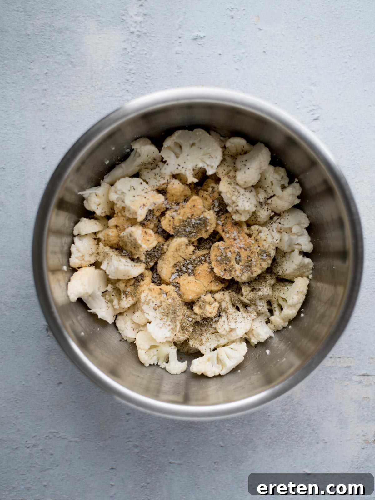 seasoned chopped cauliflower in a mixing bowl