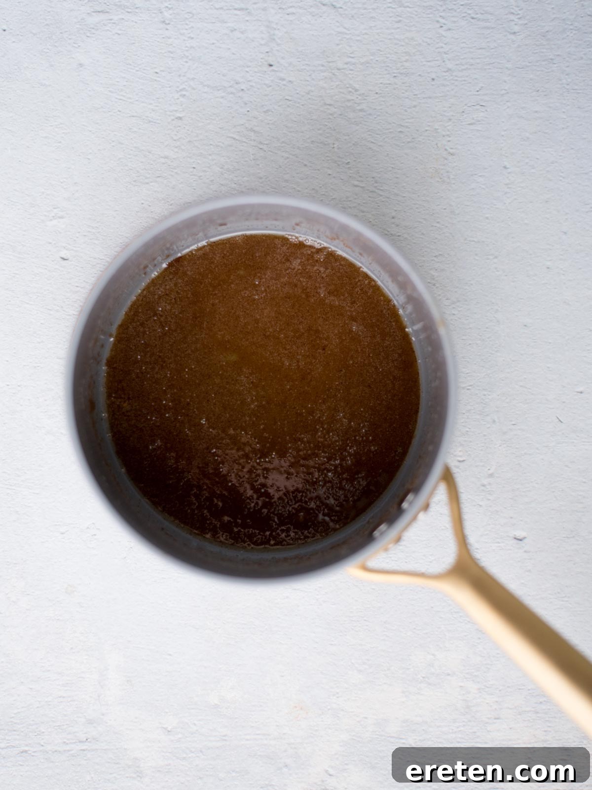 Close-up of brown sugar glaze being poured over ham
