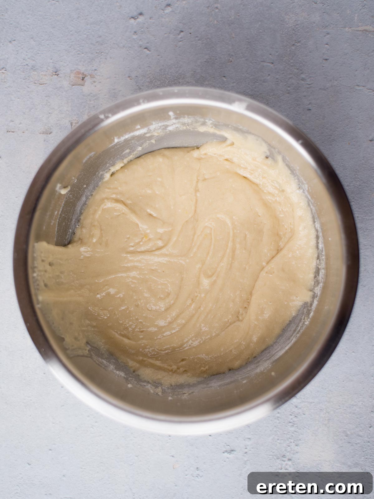 Dry ingredients and initial wet ingredients for Texas Sheet Cake, after mixing, showing a smooth, cohesive batter in a large mixing bowl.