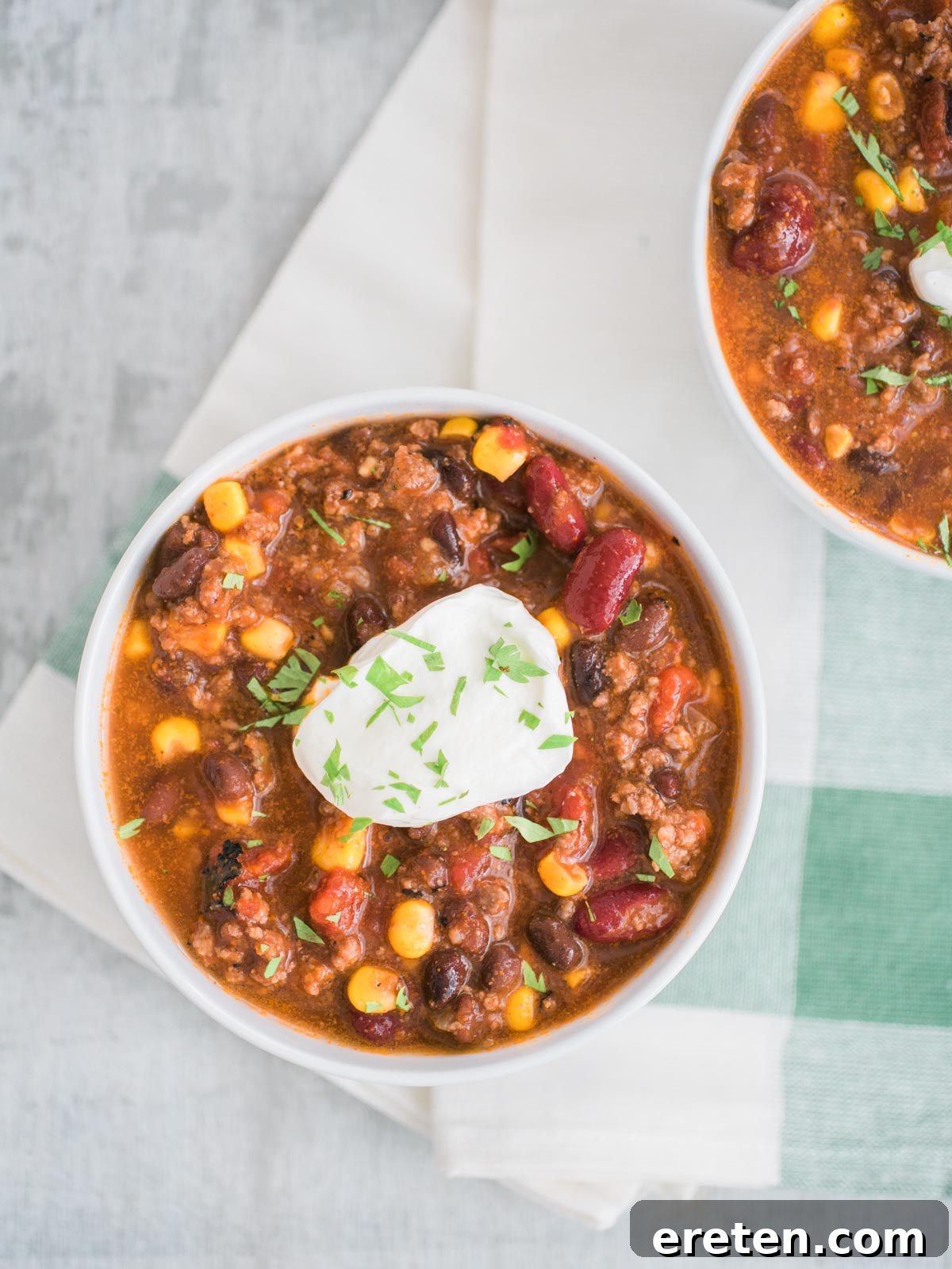 Close-up of slow cooker taco soup garnished with fresh sour cream in a white bowl