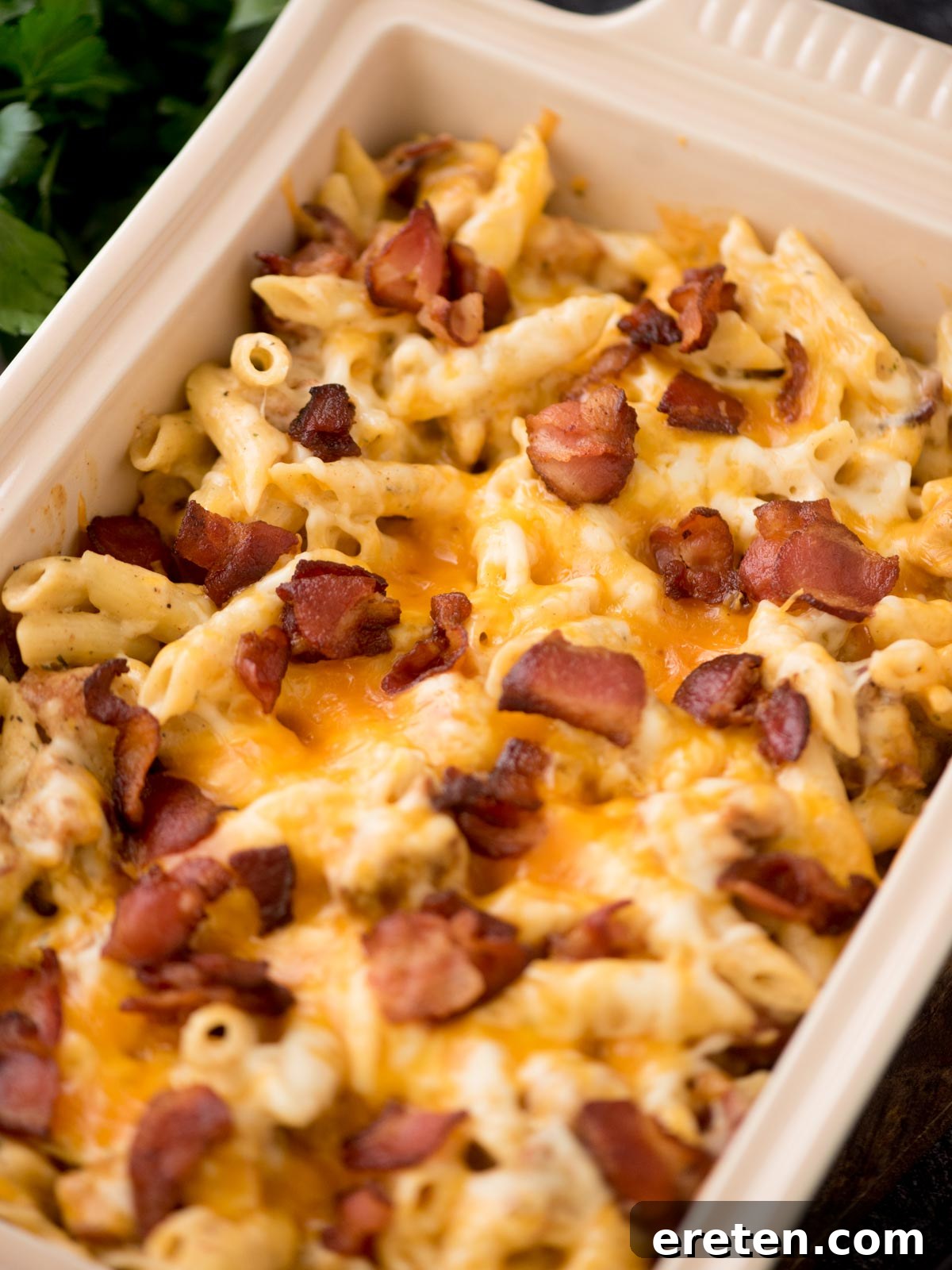 Chopped bacon pieces garnished over chicken bacon ranch pasta in a baking dish, ready to serve.