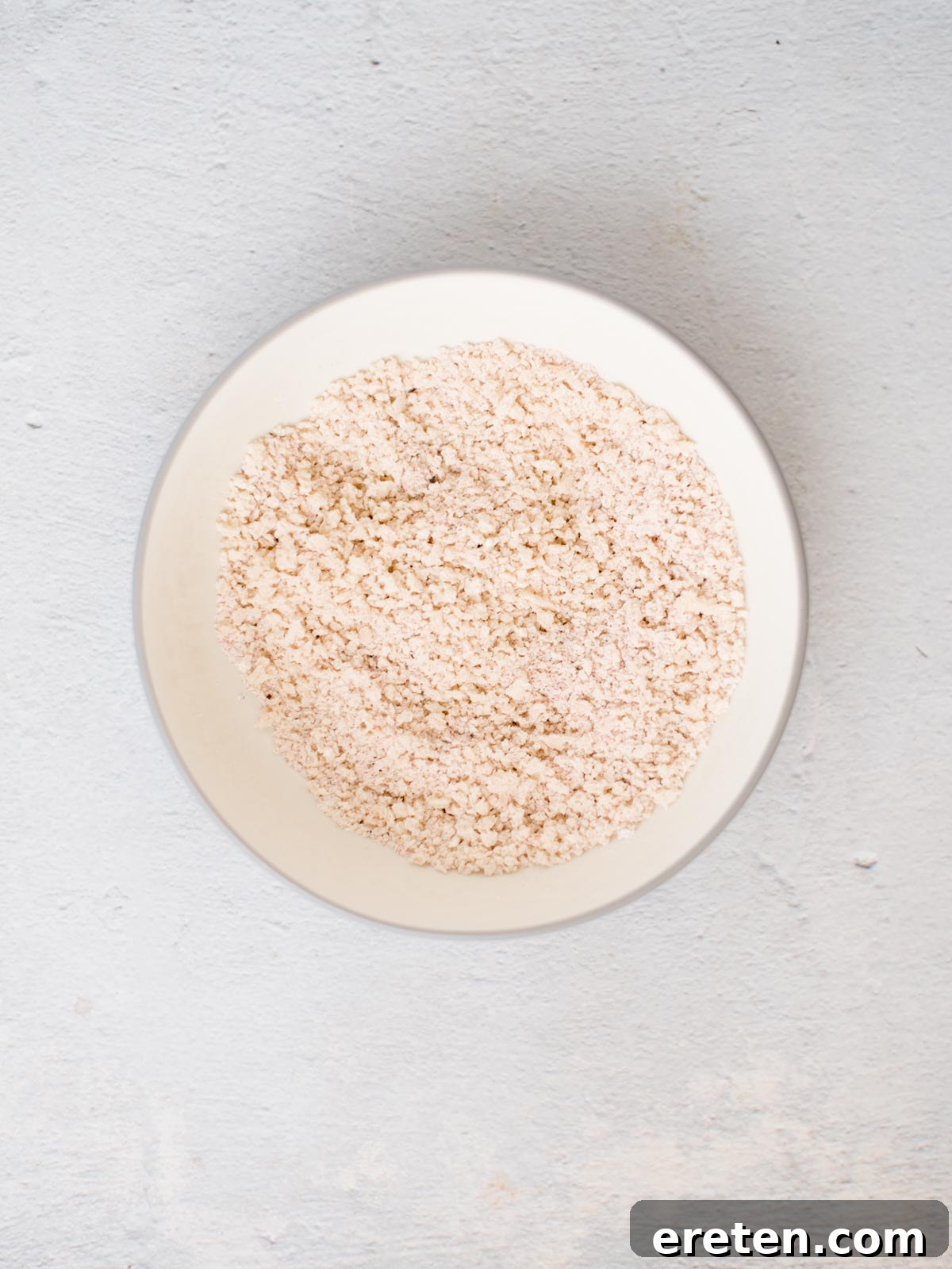 Crispy Baked Bang Bang Shrimp 4 A bowl filled with a perfectly seasoned blend of panko breadcrumbs, flour, and spices, ready for breading shrimp.