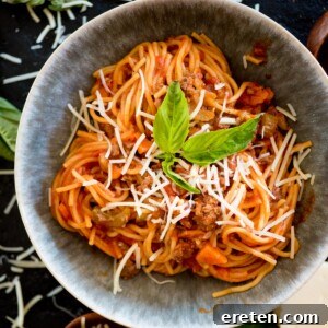 Instant Pot spaghetti in a bowl topped with fresh basil and parmesan cheese