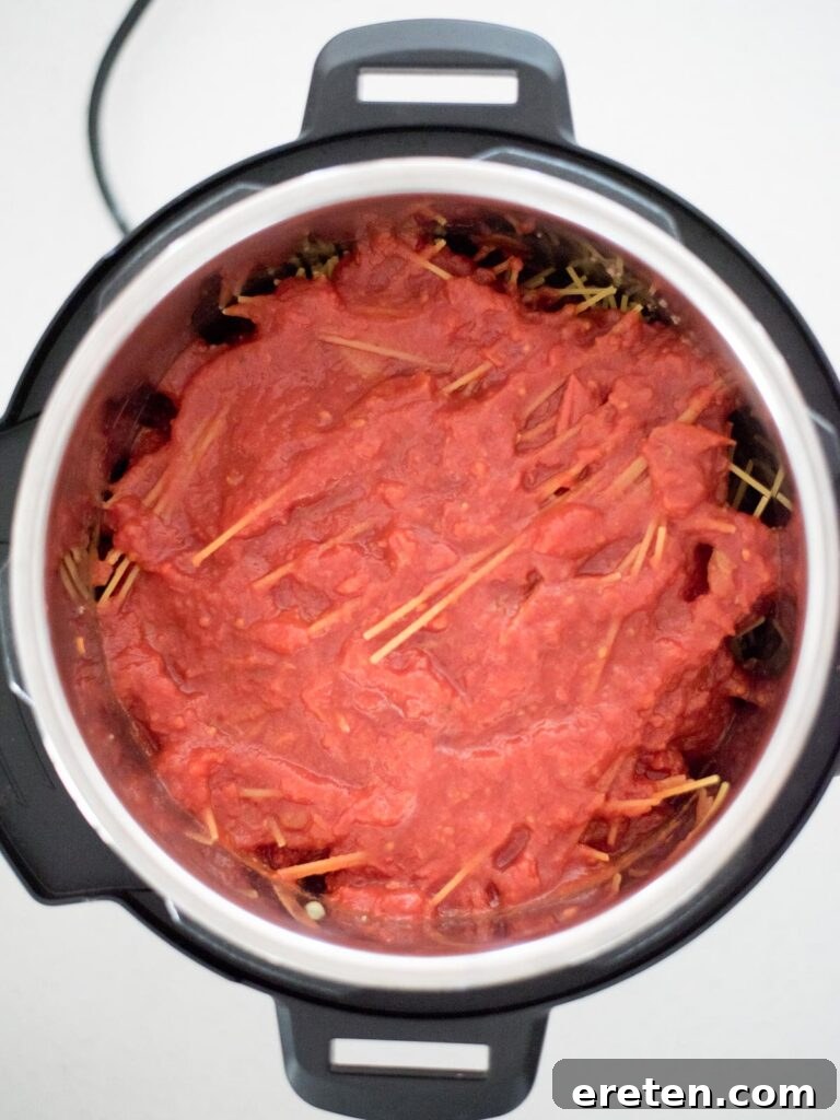Hearty Instant Pot Spaghetti with Savory Meat Sauce 7 Marinara sauce added on top of spaghetti pasta in the Instant Pot