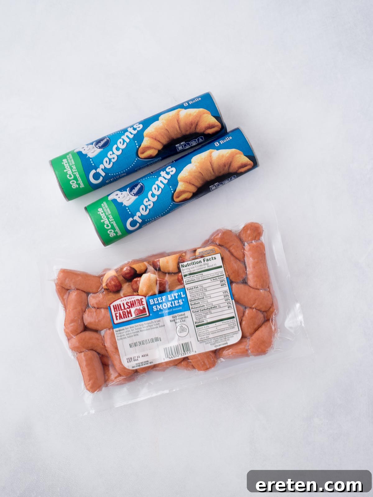 The two essential ingredients for pigs in a blanket: a package of crescent rolls and a package of Lil Smokies smoked sausages, laid out on a clean surface.