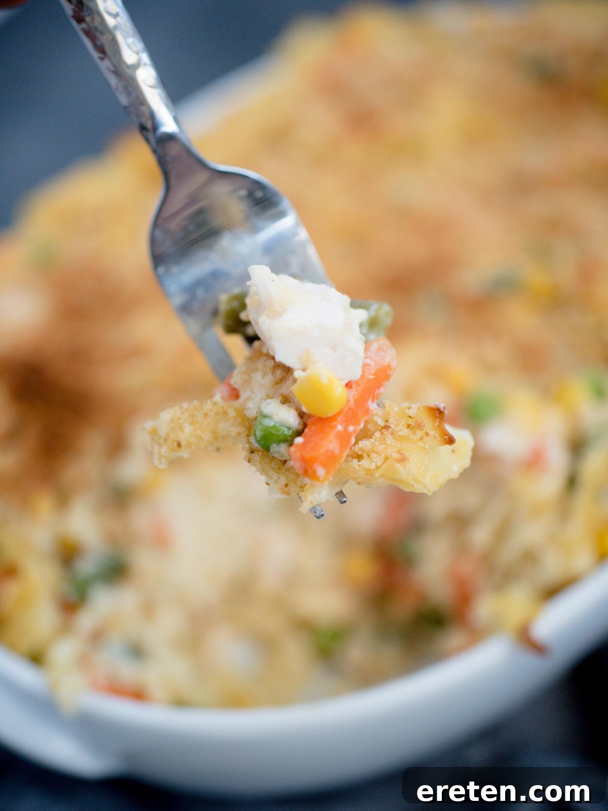 Creamy Chicken Noodle Pot Pie Casserole 3 chicken noodle casserole serving on a fork, showing creamy texture and golden topping
