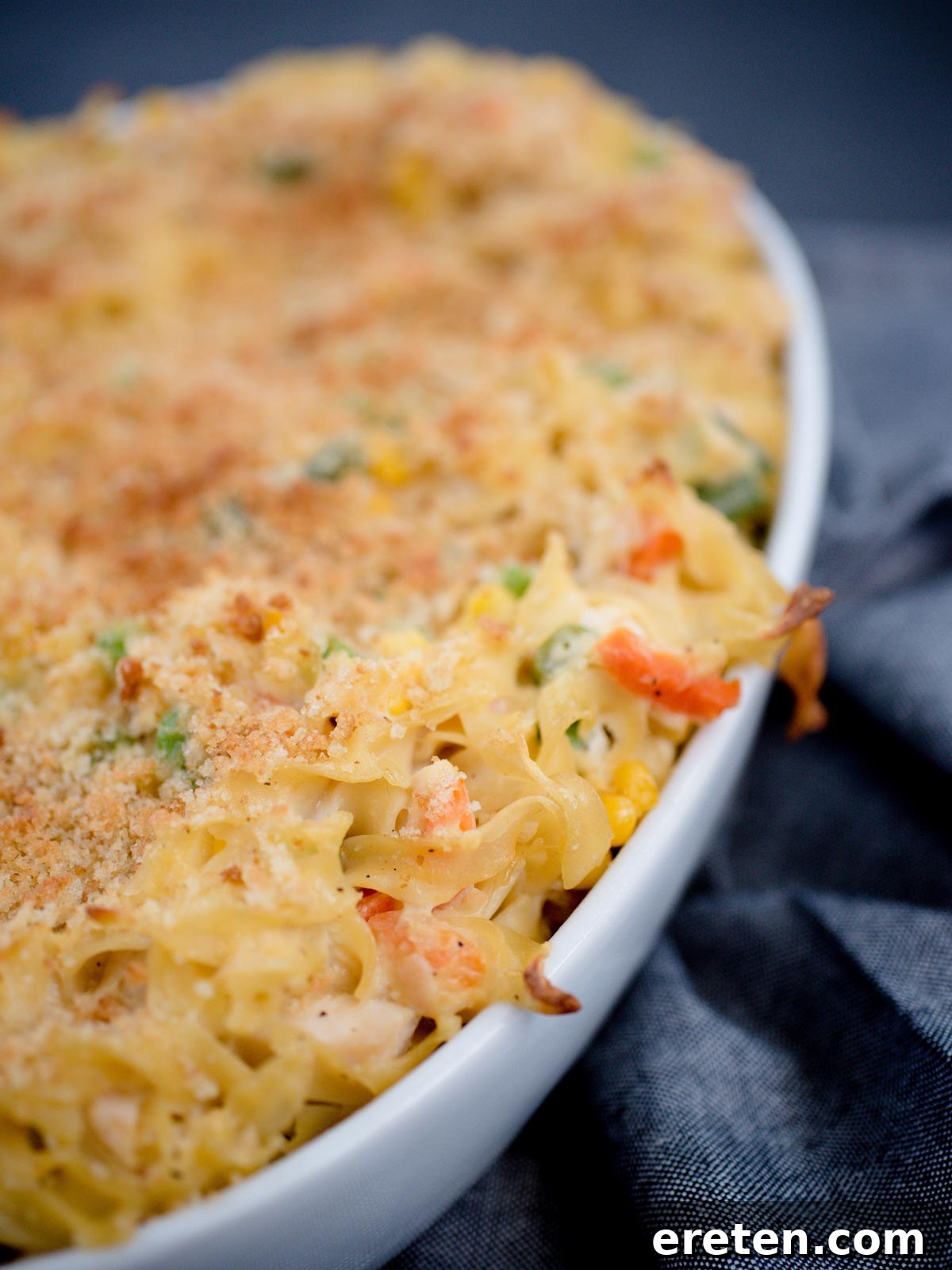 Creamy Chicken Noodle Pot Pie Casserole 4 chicken noodle casserole in a white baking dish, showing the bubbly, golden topping