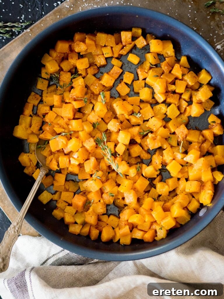 Pan-Seared Butternut Squash Delight 2 Sautéed butternut squash in a skillet, garnished with fresh thyme leaves, ready to be served as a delightful side dish.