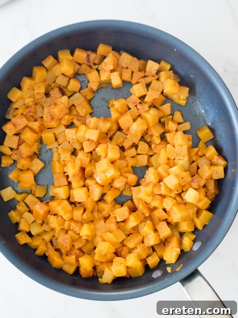 Pan-Seared Butternut Squash Delight 11 Cinnamon and nutmeg thoroughly mixed into sautéed butternut squash, distributing warm spices evenly.