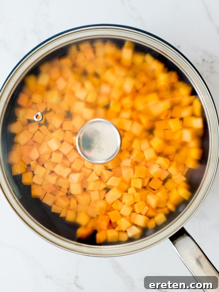 Pan-Seared Butternut Squash Delight 8 A lid securely placed on a skillet, covering butternut squash and butter as they cook.