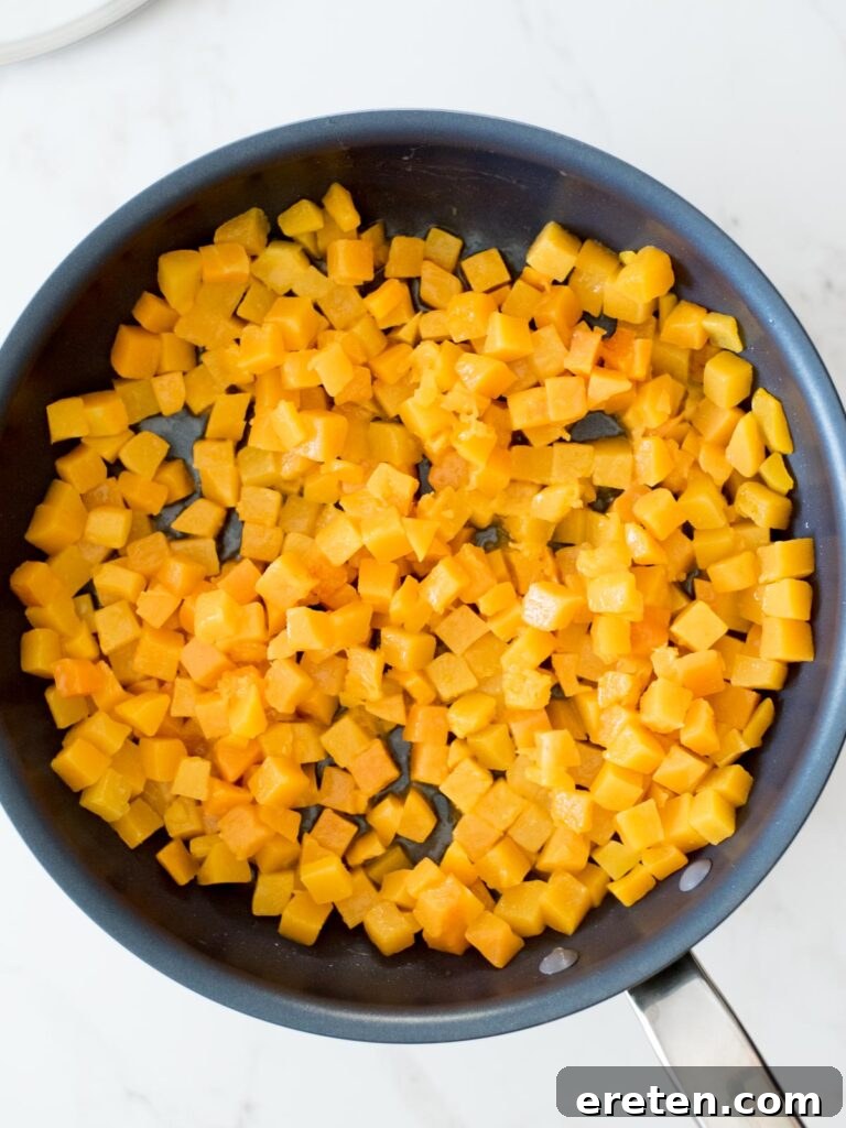 Pan-Seared Butternut Squash Delight 9 Sautéed butternut squash in a skillet, appearing softened and cooked down after its covered cooking period.