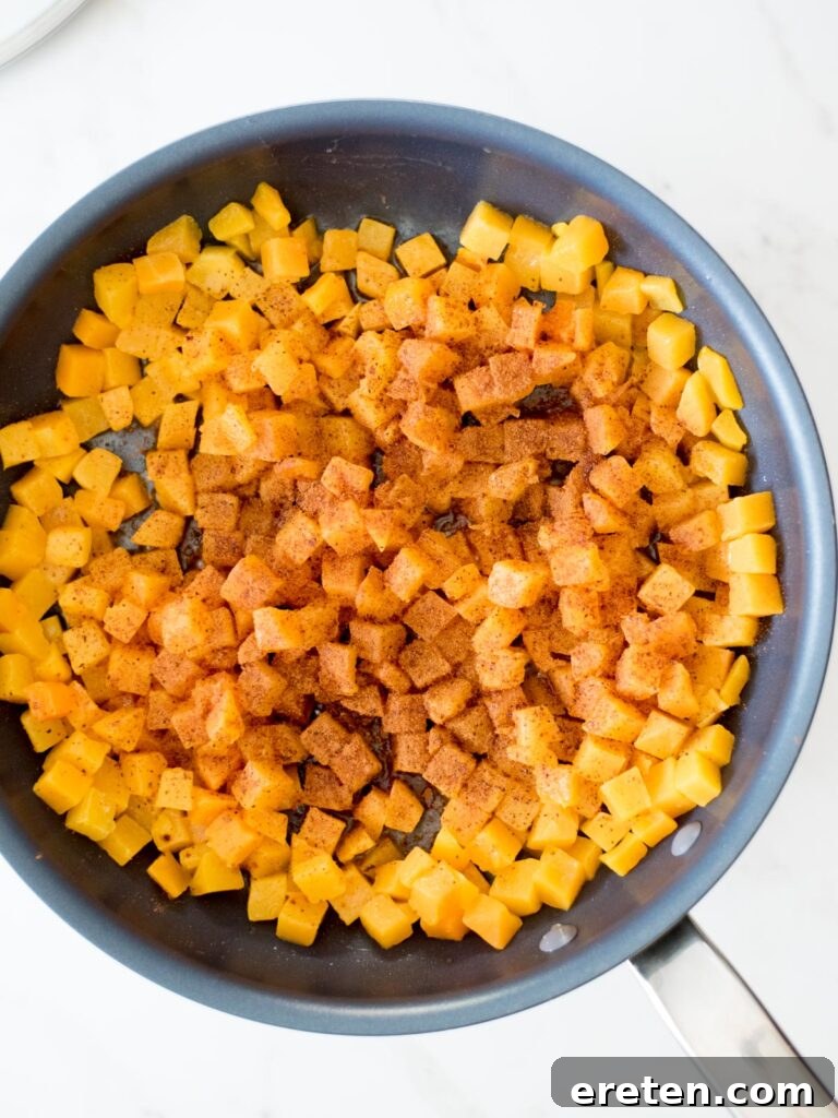 Pan-Seared Butternut Squash Delight 10 A sprinkle of cinnamon and nutmeg gracefully falling onto tender butternut squash in a skillet.