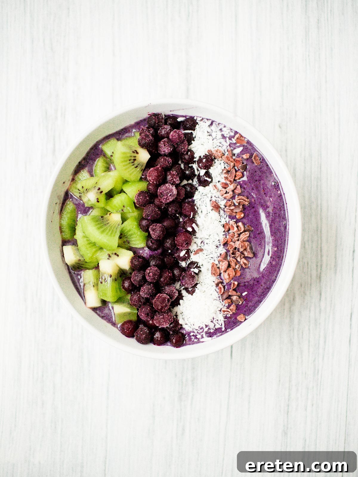 Close-up of a creamy blueberry banana smoothie bowl with various toppings, emphasizing its fresh and appealing texture.