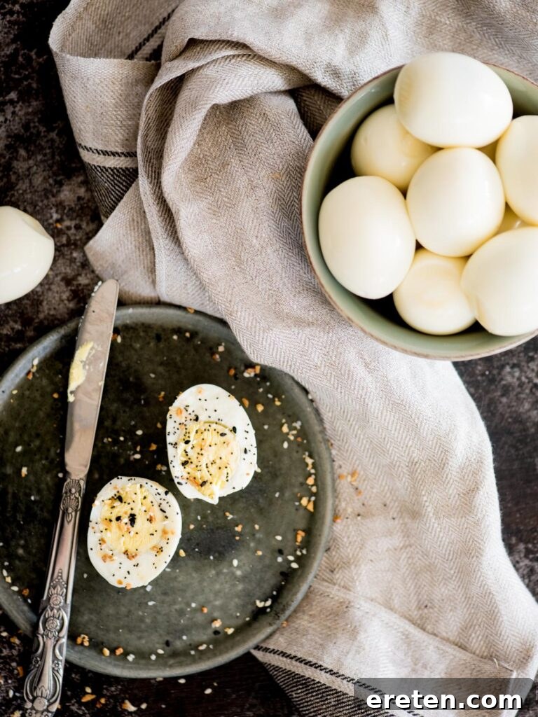Foolproof Hard Boiled Eggs in Instant Pot 2 Perfectly hard-boiled eggs in a bowl with a sliced egg seasoned with everything bagel seasoning, ready to eat.