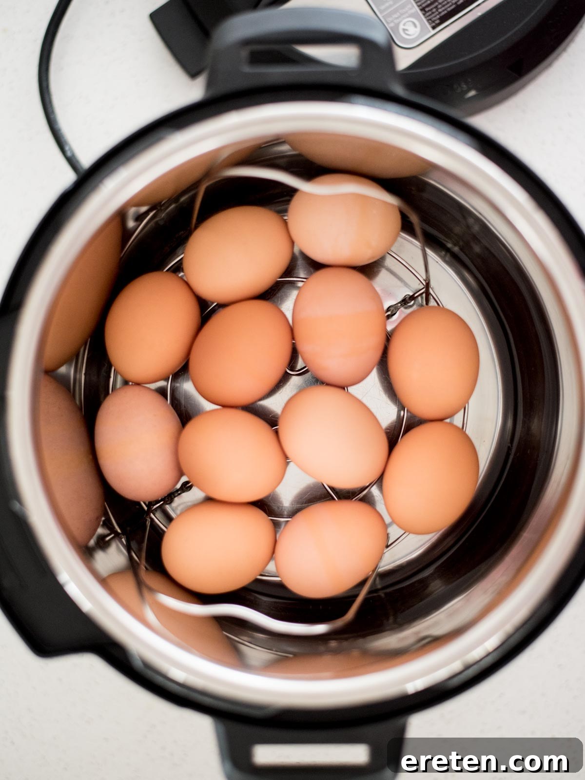 Foolproof Hard Boiled Eggs in Instant Pot 5 Eggs neatly arranged on the trivet inside an Instant Pot, before cooking.