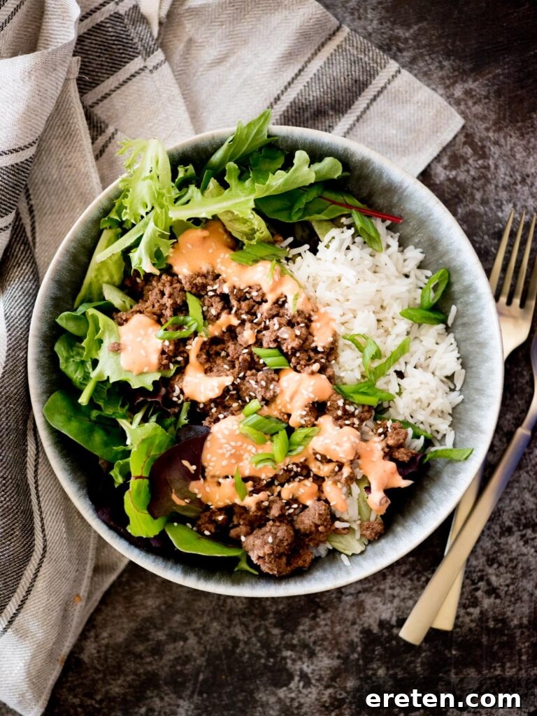 korean beef bowls topped with spicy mayo and sesame seeds