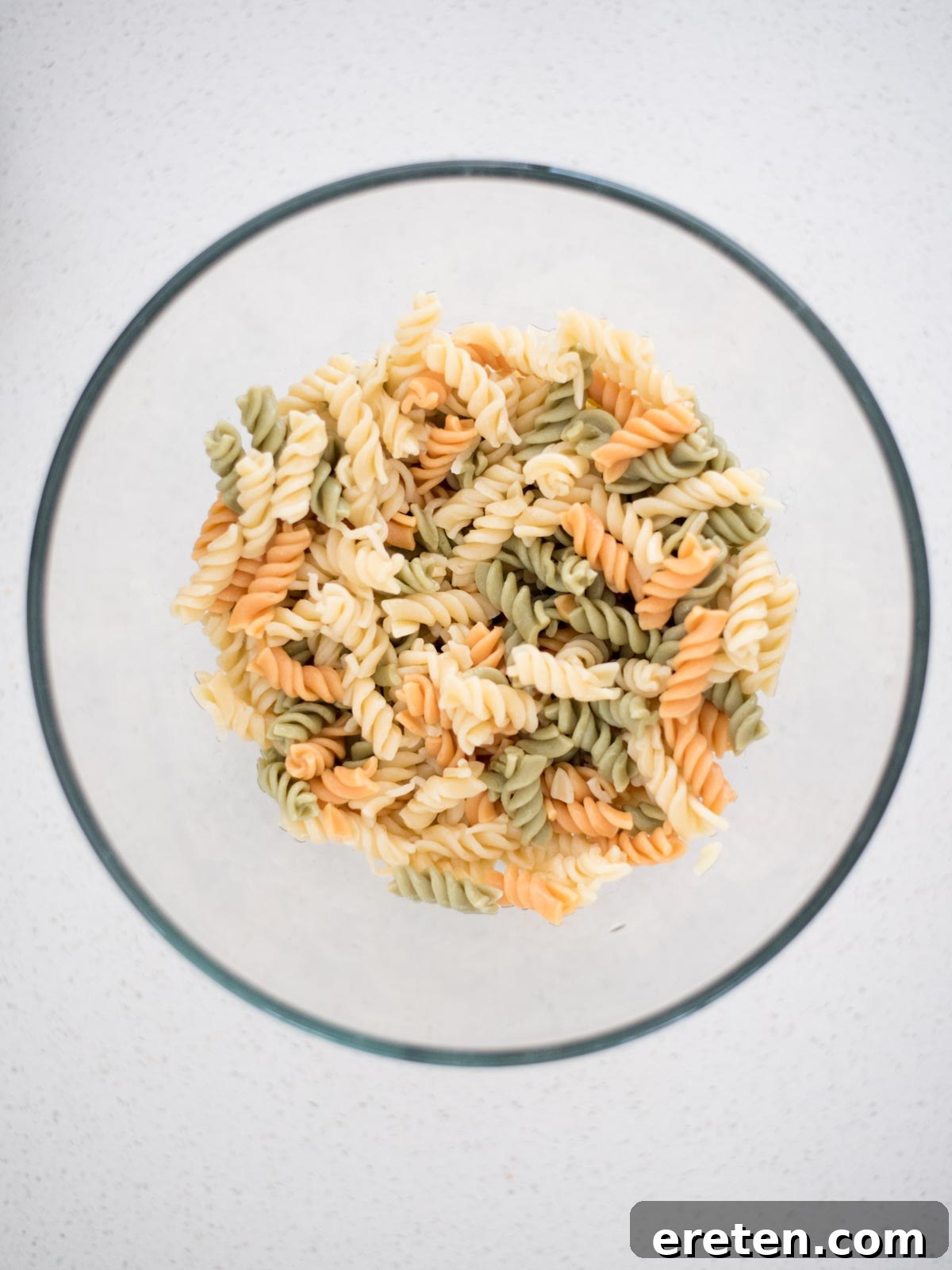 Perfectly cooked al dente rotini pasta cooling in a large mixing bowl, the base for Zesty Italian Pasta Salad